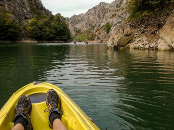 Low section of man sitting on boat over river