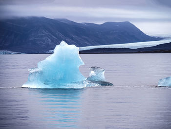 Scenic view of sea and mountains against sky