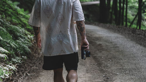 Man from behind photographing nature with a vintage camera person