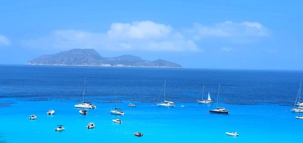 Sailboats in sea against sky