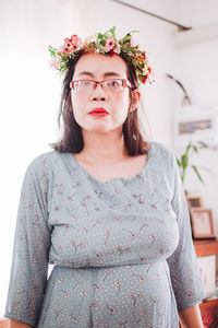 Portrait of young woman standing against white background