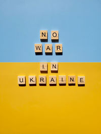 A lot of yellow stickers with words on blue background. concept of  support. stop war in ukraine