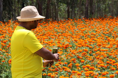 Man photographing flowers through mobile phone