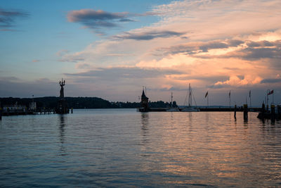 Sailboats in sea against sky during sunset