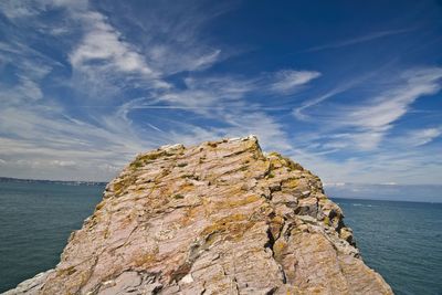 Rock formations by sea against sky