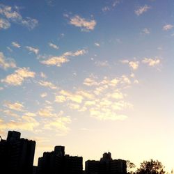 Low angle view of buildings against cloudy sky