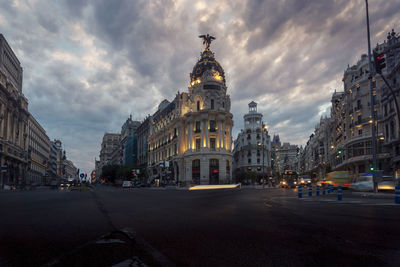 Low angle of famous metropolis building under cloudy sky in evening in madrid