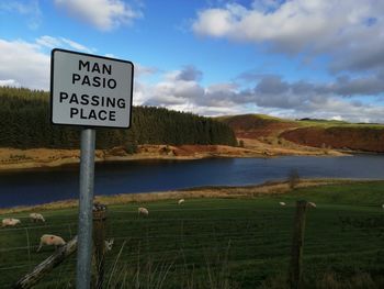 Information sign on landscape against sky