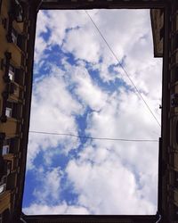 Low angle view of buildings against cloudy sky