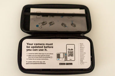 Close-up of digital camera on table against white background