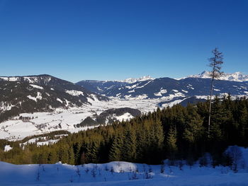 Scenic view of snowcapped mountains against clear blue sky