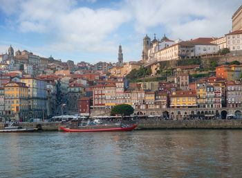 River by buildings against cloudy sky