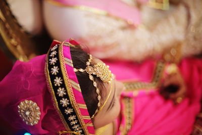 Close-up of bride wearing sari and jewelry during wedding ceremony