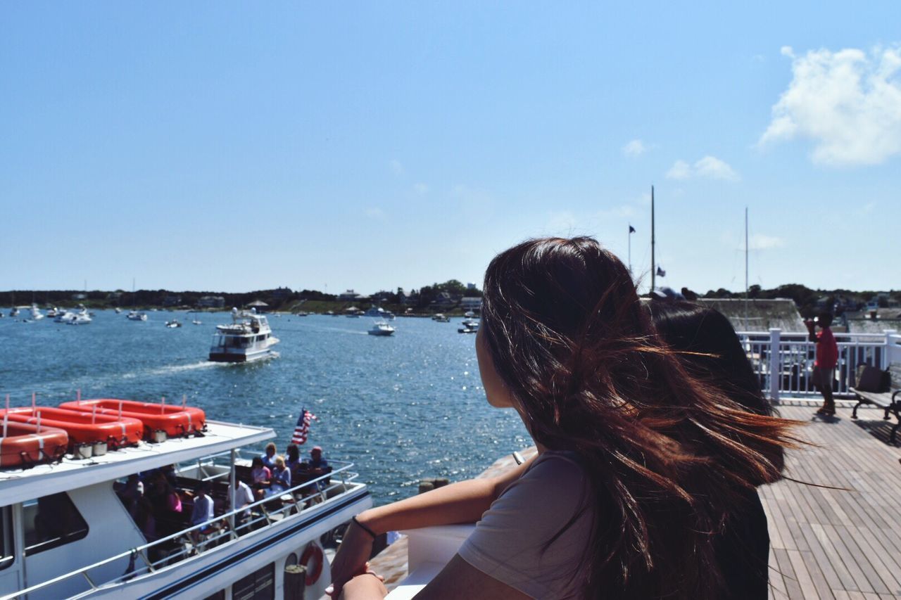 REAR VIEW OF WOMAN OVERLOOKING RIVER