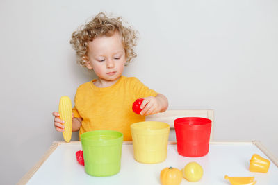 Toddler playing with learning toys at home. baby sorting organising objects with specific colors