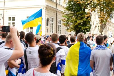 People protesting on street with ukrainian flag