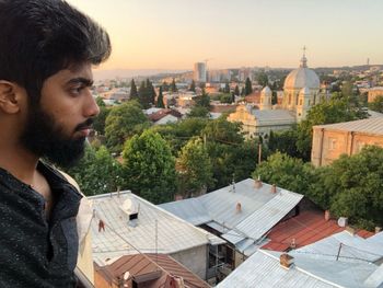 Man looking at city buildings against sky