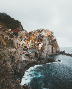 Buildings by sea against sky