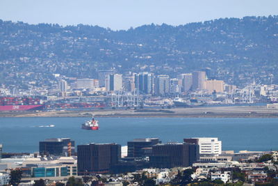 High angle view of city by sea against sky