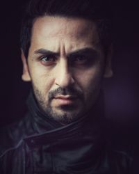 Close-up portrait of young man against black background