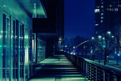Illuminated walkway in city at night