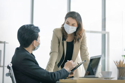 Business person wearing mask working at office