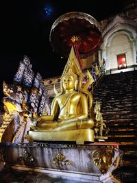 Low angle view of statue in temple against sky