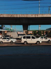 Cars on bridge against sky in city