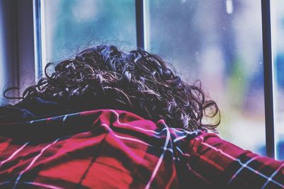 Close-up of woman relaxing on window at home