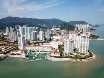 High angle view of city by sea against sky