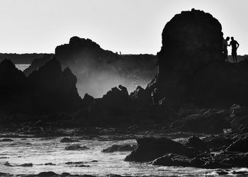 Panoramic shot of rocks by sea against sky