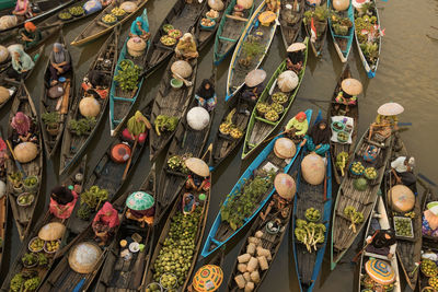 Aerial view of people in boat by vegetables for sale in market