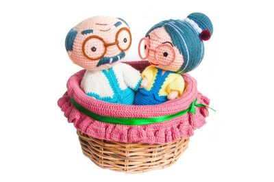 Close-up of toys in basket against white background