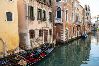 Boats in canal amidst buildings in city