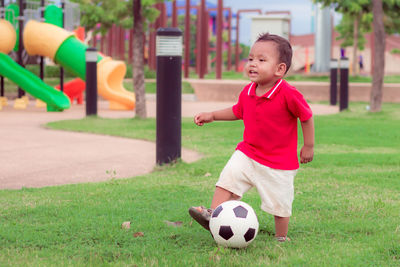 Boy playing with ball on soccer field