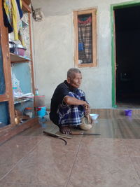 Full length of man sitting outside building