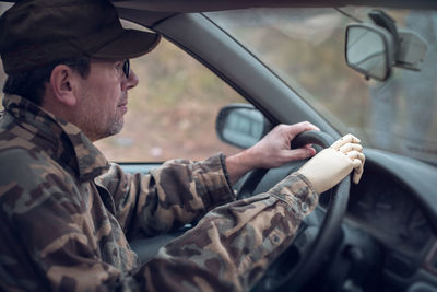 Side view of man holding car