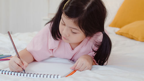 Close-up of girl wearing mask on bed at home