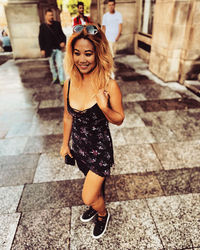 Young woman smiling while standing on footpath