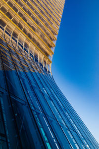 Low angle view of modern building against blue sky