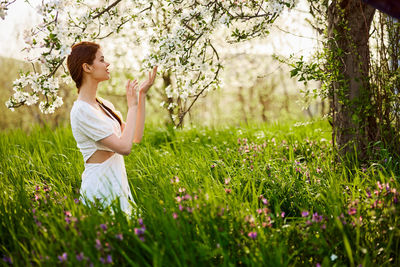 Side view of woman standing on grassy field