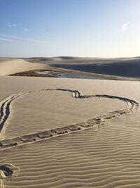 Heart shape at desert against sky