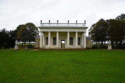 Lawn by building against sky