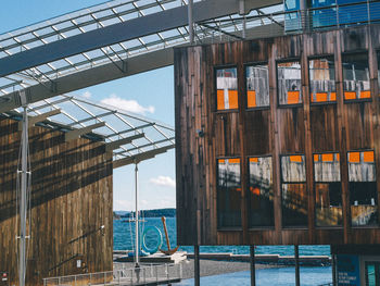 Reflection of building in sea against sky