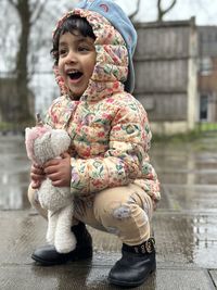 Portrait of young woman sitting on retaining wall