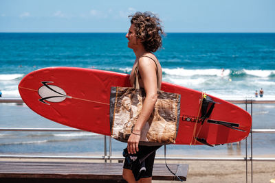 Rear view of woman on beach against sky