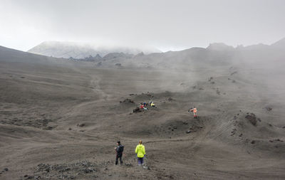 People on desert against sky