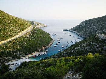 Aerial view of sea by mountains against sky