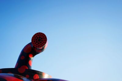 Low angle view of balloons against clear blue sky