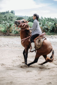 Full length of man riding horse on land